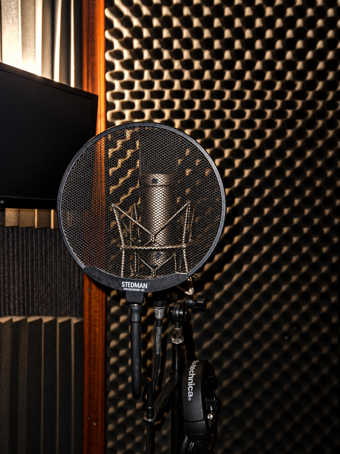 Neumann microphone, pop filter, and headphones in Black Box’s vocal booth